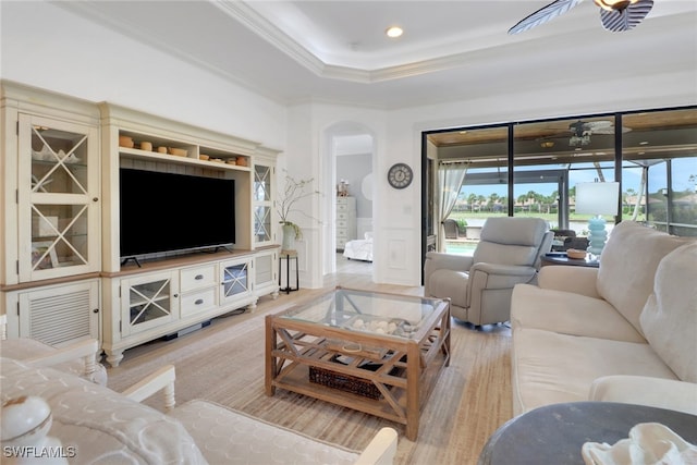 living room with ornamental molding, ceiling fan, light hardwood / wood-style floors, and a tray ceiling