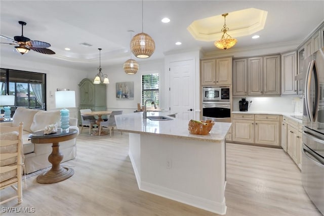 kitchen with sink, stainless steel appliances, decorative light fixtures, and a raised ceiling