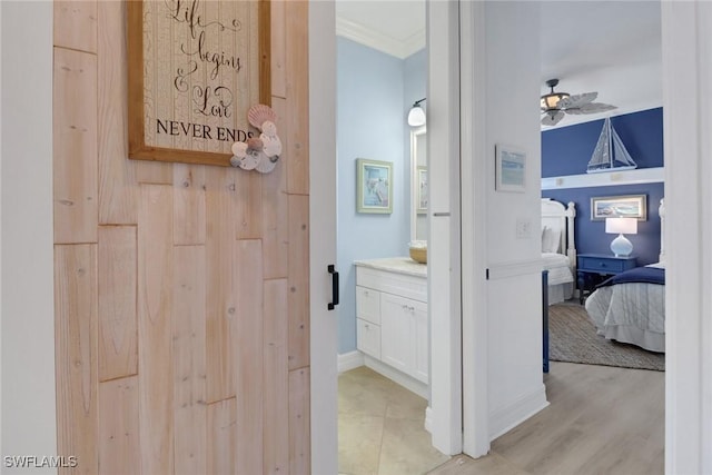 bathroom with wood-type flooring, vanity, and crown molding