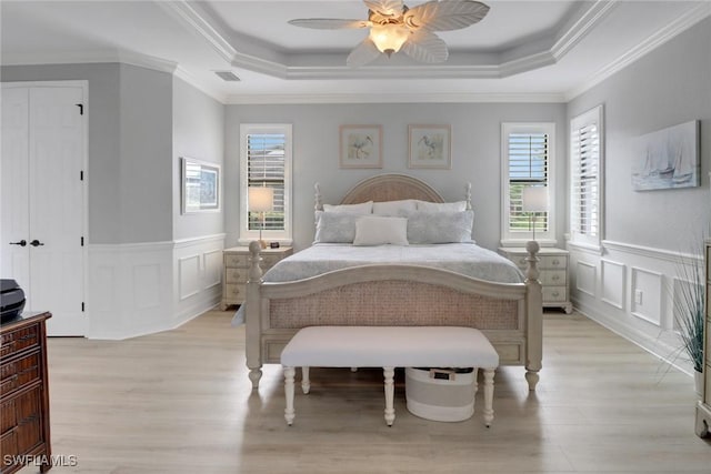 bedroom with a raised ceiling, ceiling fan, and ornamental molding