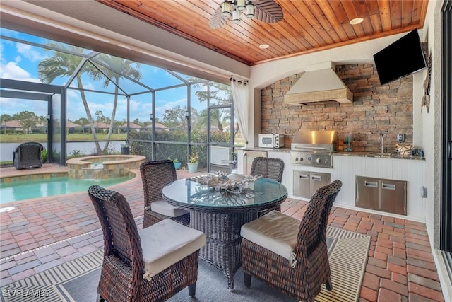 view of patio featuring a swimming pool with hot tub, exterior kitchen, glass enclosure, a grill, and a water view