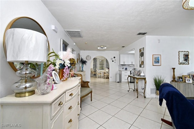 hallway featuring light tile patterned floors and a textured ceiling