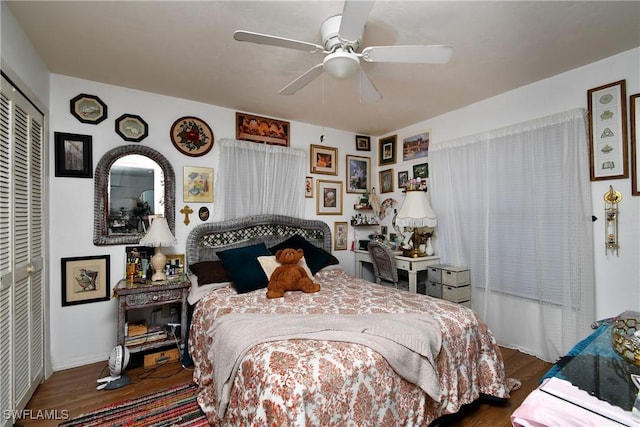 bedroom with ceiling fan, a closet, and dark wood-type flooring