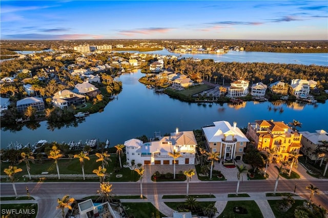 aerial view at dusk featuring a water view