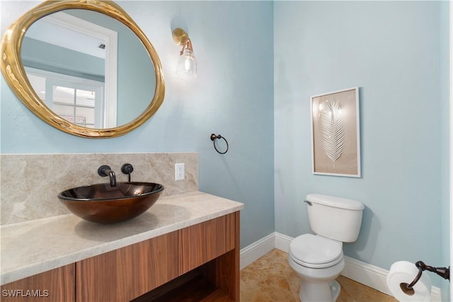 bathroom with toilet, decorative backsplash, tile patterned floors, and vanity