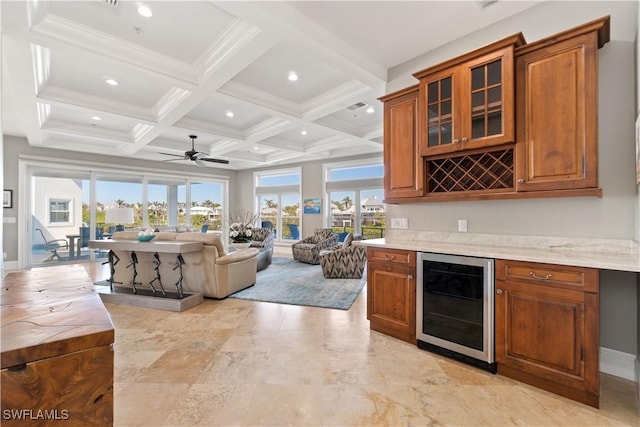 interior space with beamed ceiling, wine cooler, bar, ceiling fan, and coffered ceiling