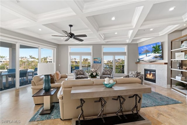 living room with ceiling fan, a wealth of natural light, beam ceiling, and coffered ceiling