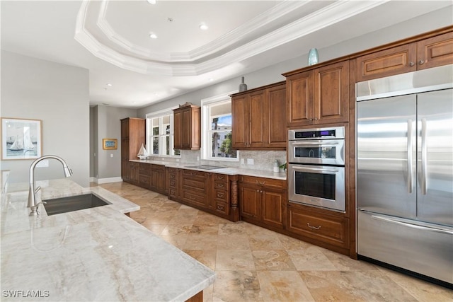 kitchen with stainless steel appliances, backsplash, a raised ceiling, crown molding, and sink