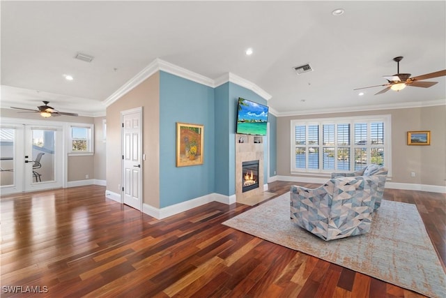 living room with a healthy amount of sunlight, a fireplace, and crown molding