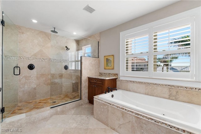 bathroom featuring a healthy amount of sunlight, vanity, and shower with separate bathtub