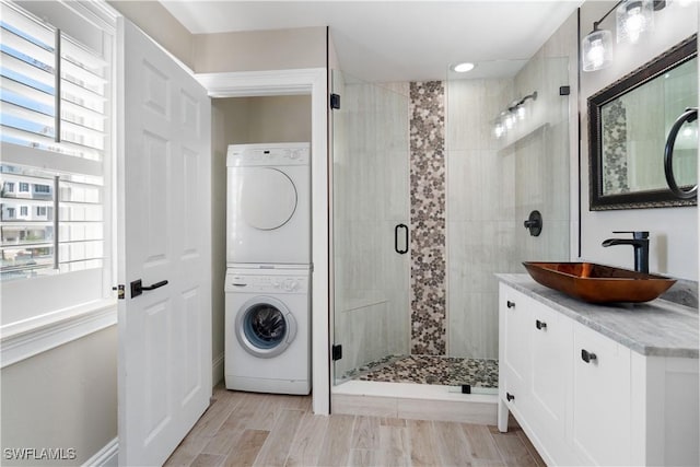 laundry area with stacked washer and clothes dryer and sink