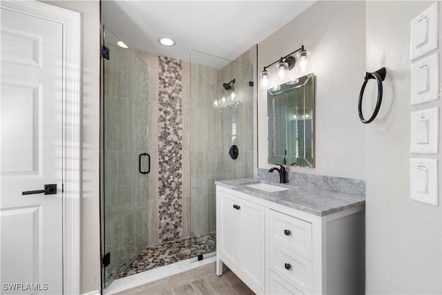 bathroom featuring walk in shower and vanity