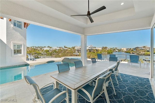 view of patio featuring a water view, ceiling fan, and a fenced in pool