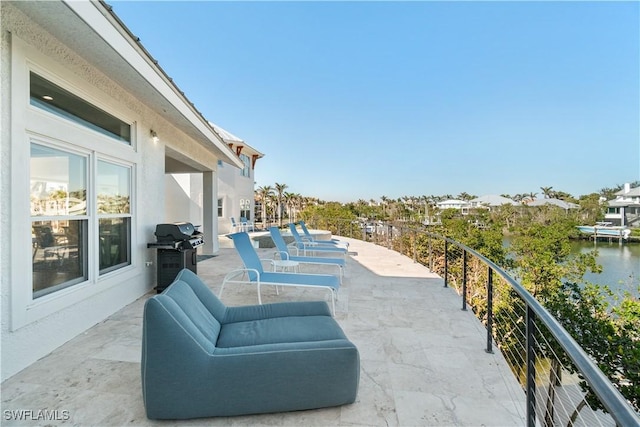 view of patio / terrace with a water view and a grill