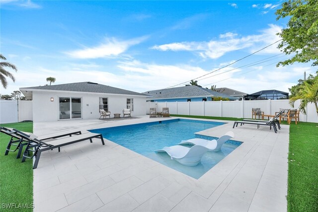 view of swimming pool featuring a patio area and a lawn