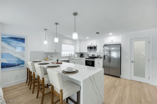 639 98th Ave N, Naples, FL 34108 - kitchen with appliances with stainless steel finishes, a sink, a peninsula, light stone countertops, and light wood-type flooring