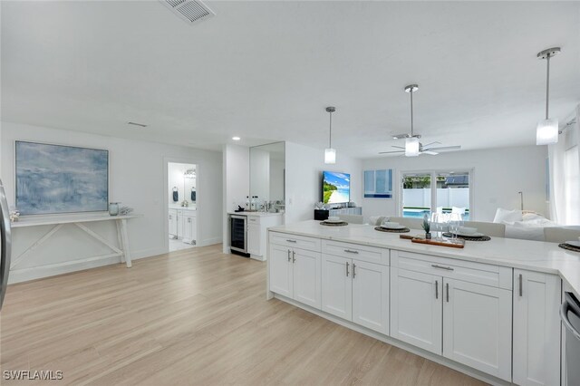 kitchen featuring white cabinets, decorative light fixtures, ceiling fan, and beverage cooler