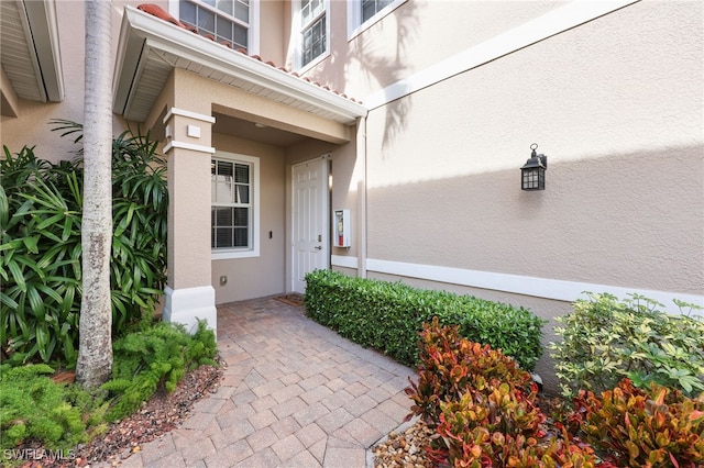 doorway to property featuring stucco siding