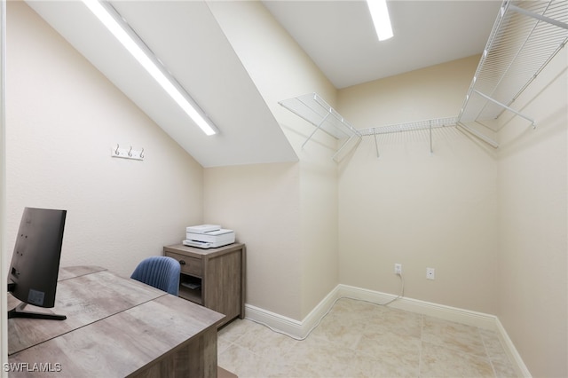 office with lofted ceiling and baseboards