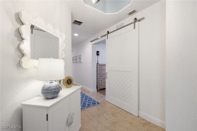 hallway featuring recessed lighting, visible vents, baseboards, and a barn door