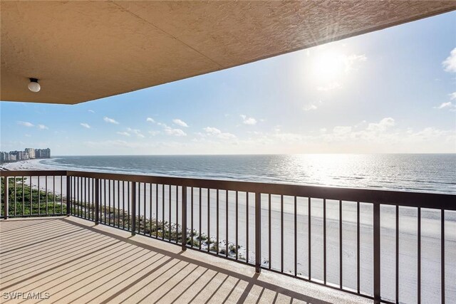 balcony with a water view and a beach view