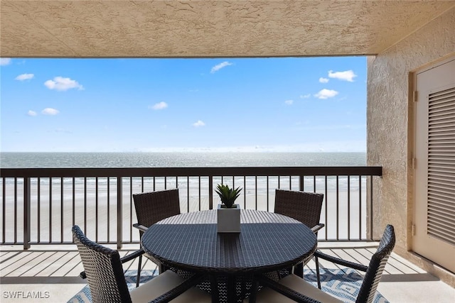 balcony featuring a water view and a beach view