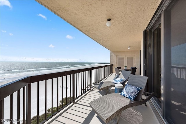 balcony with a water view and a beach view