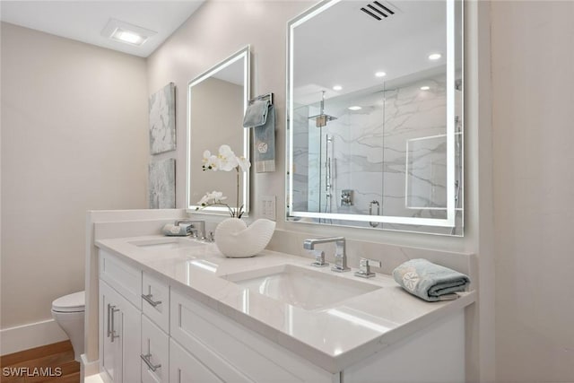 bathroom featuring hardwood / wood-style floors, vanity, toilet, and walk in shower