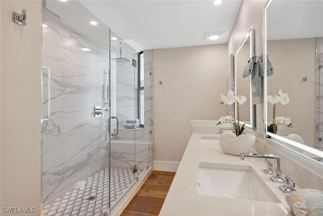 bathroom featuring walk in shower, vanity, and hardwood / wood-style flooring