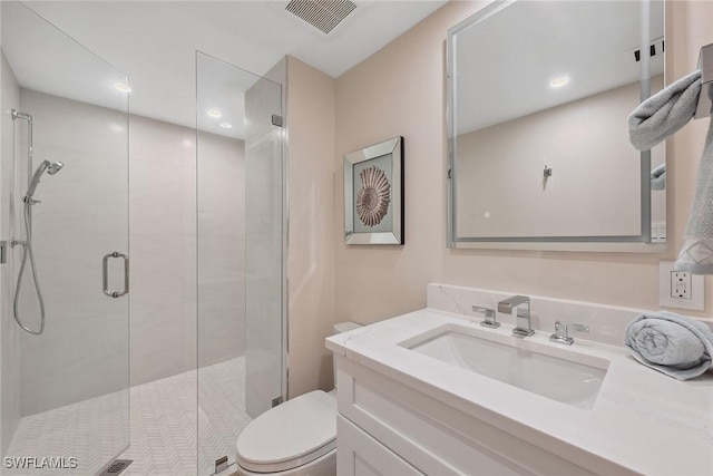 bathroom with vanity, toilet, and a shower with shower door