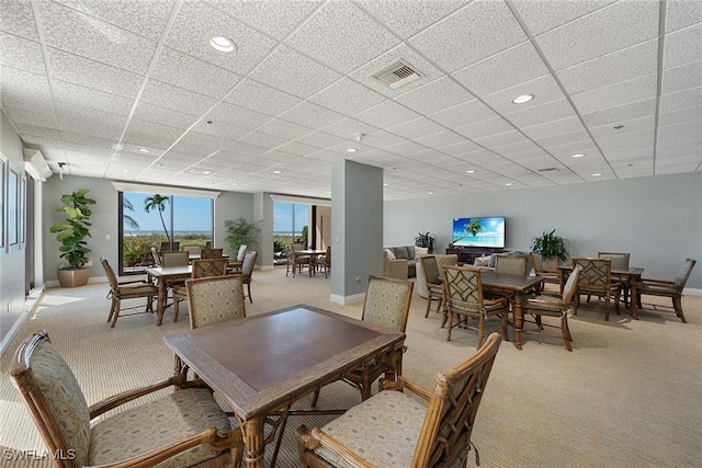 dining space with light carpet and a paneled ceiling