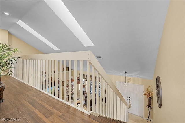 stairs featuring lofted ceiling and hardwood / wood-style floors