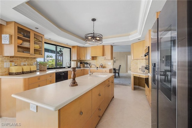 kitchen with dishwasher, a raised ceiling, a center island with sink, stainless steel refrigerator with ice dispenser, and sink