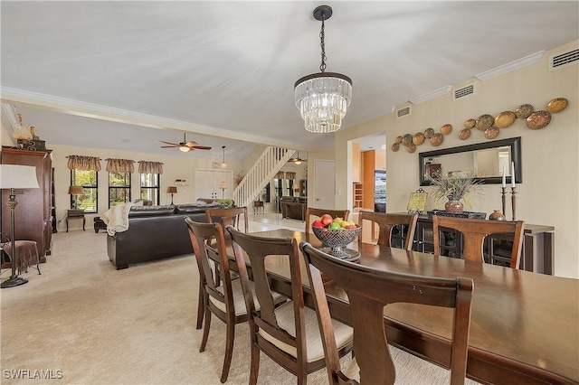 dining area with ornamental molding, light carpet, and ceiling fan with notable chandelier