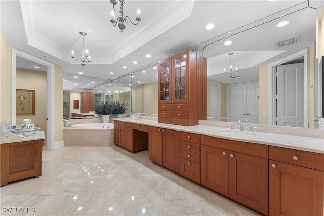 bathroom featuring a raised ceiling, tiled bath, crown molding, and vanity