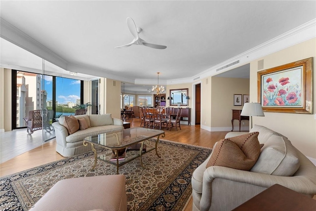 living room featuring ceiling fan with notable chandelier, light wood-type flooring, and ornamental molding