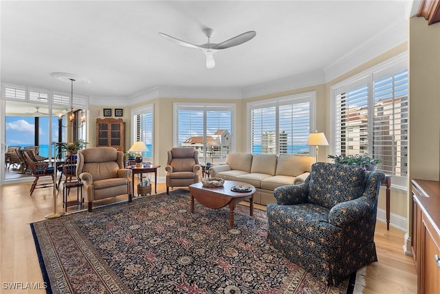 living room featuring light hardwood / wood-style floors, ceiling fan, and ornamental molding