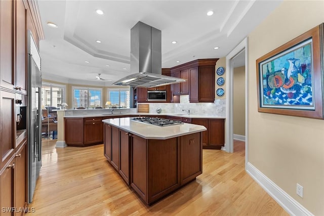 kitchen with island range hood, a kitchen island, kitchen peninsula, and stainless steel appliances