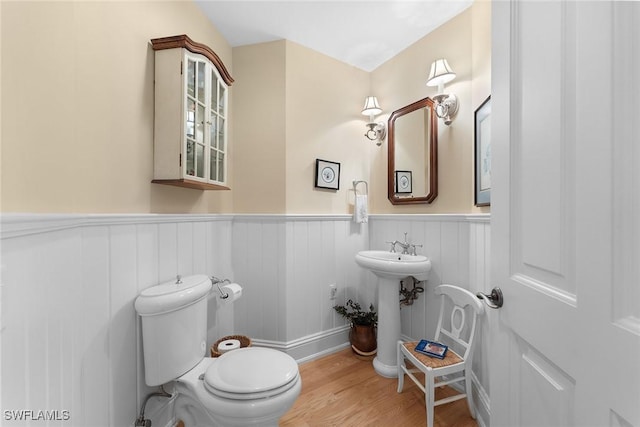 bathroom with hardwood / wood-style flooring, toilet, and sink