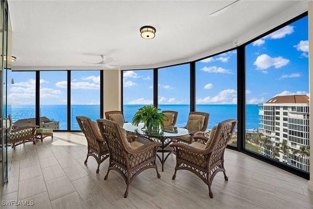 sunroom with a water view and ceiling fan