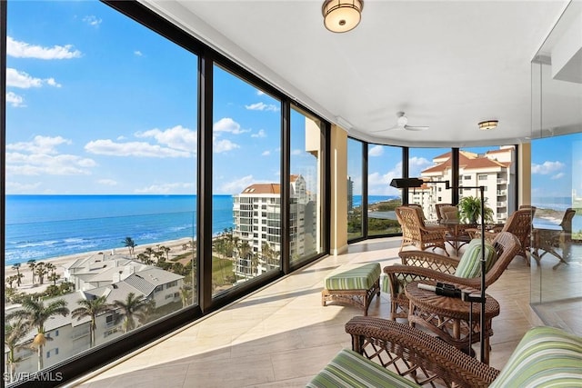 sunroom featuring a water view and a view of the beach