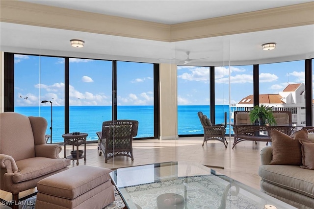 living room with floor to ceiling windows, a water view, plenty of natural light, and ceiling fan