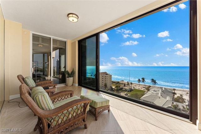 balcony with a water view and a view of the beach