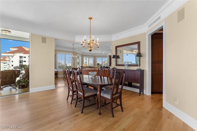 dining room with crown molding, a chandelier, and light wood-type flooring