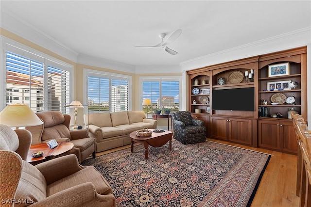 living room featuring light hardwood / wood-style flooring, ceiling fan, and crown molding