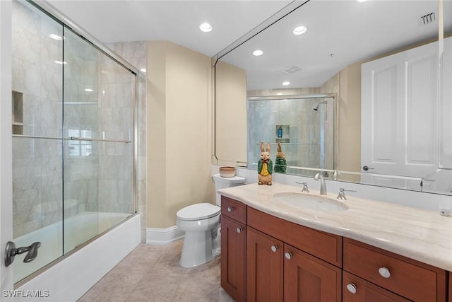 full bathroom featuring tile patterned floors, toilet, vanity, baseboards, and combined bath / shower with glass door