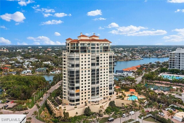 aerial view of a pool, a large body of water, and apartment complex / building