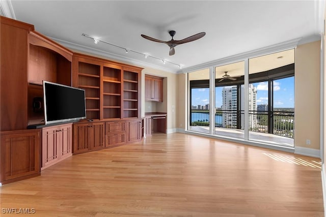 unfurnished living room with ceiling fan, light wood-style flooring, rail lighting, baseboards, and crown molding