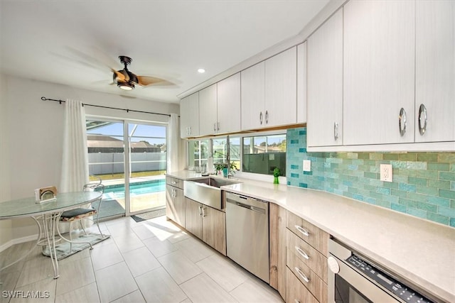 kitchen featuring dishwasher, light tile patterned floors, decorative backsplash, ceiling fan, and sink