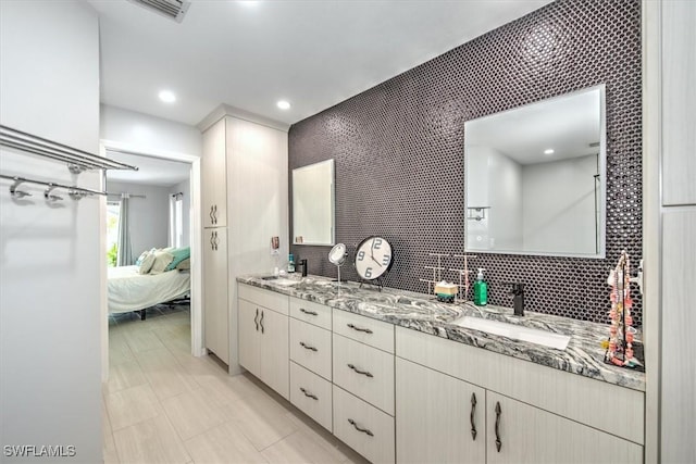 bathroom featuring vanity and decorative backsplash